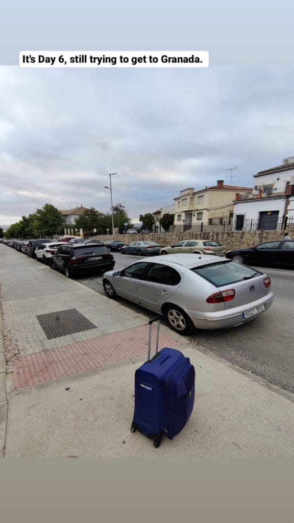 Quiet residential street in Antequera the next morning, white houses and a suitcase
