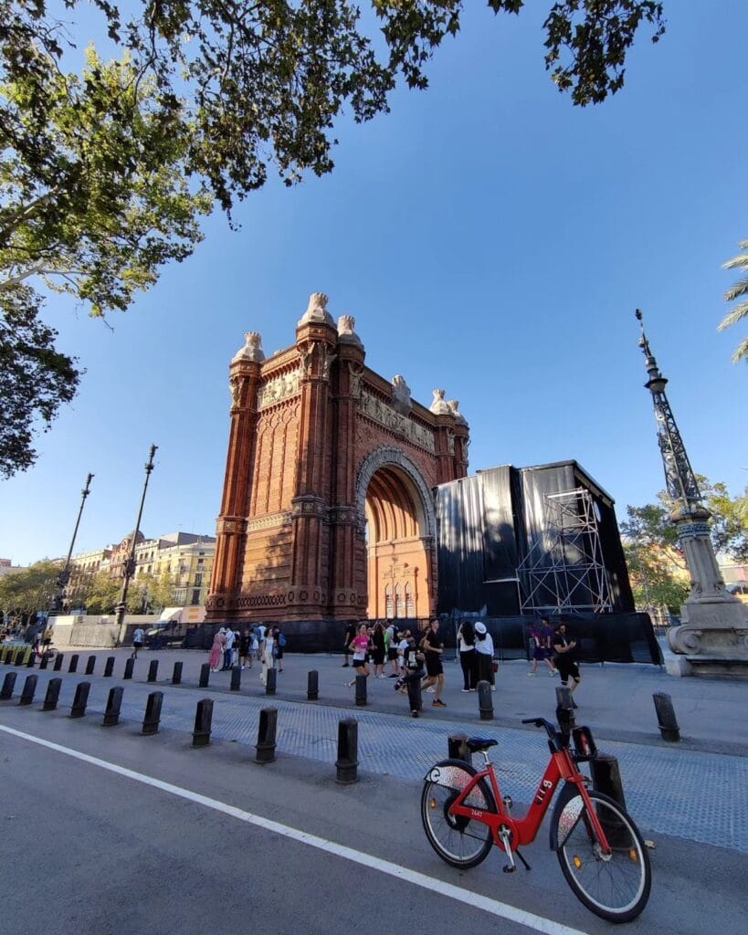 Red bike-share bicycle in front of the Arc de Triomf in Barcelona