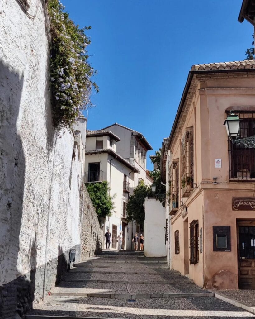 Whitewashed stepped lane with wisteria in the Albaicin, Granada