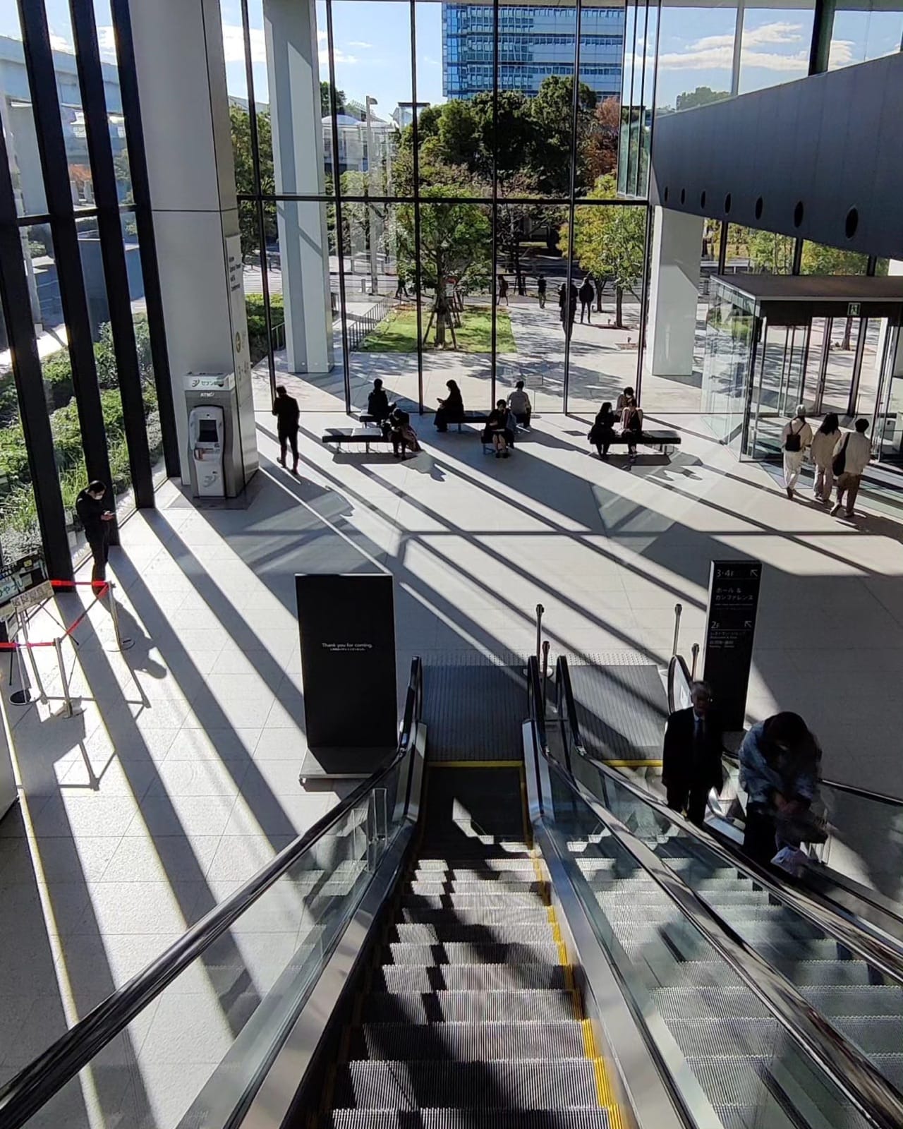 Morning sun casting long shadows across the glass atrium of the Open Source Summit Japan venue