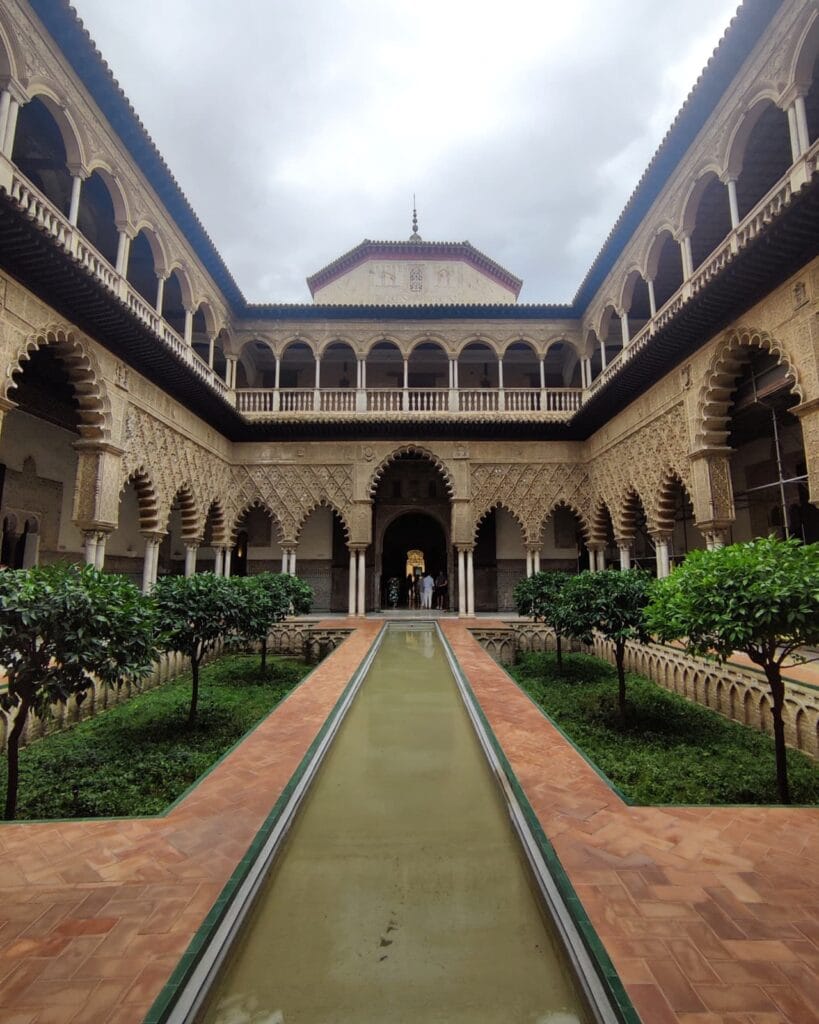Mudejar arched gallery and reflecting water channel in a courtyard of the Real Alcazar, Seville
