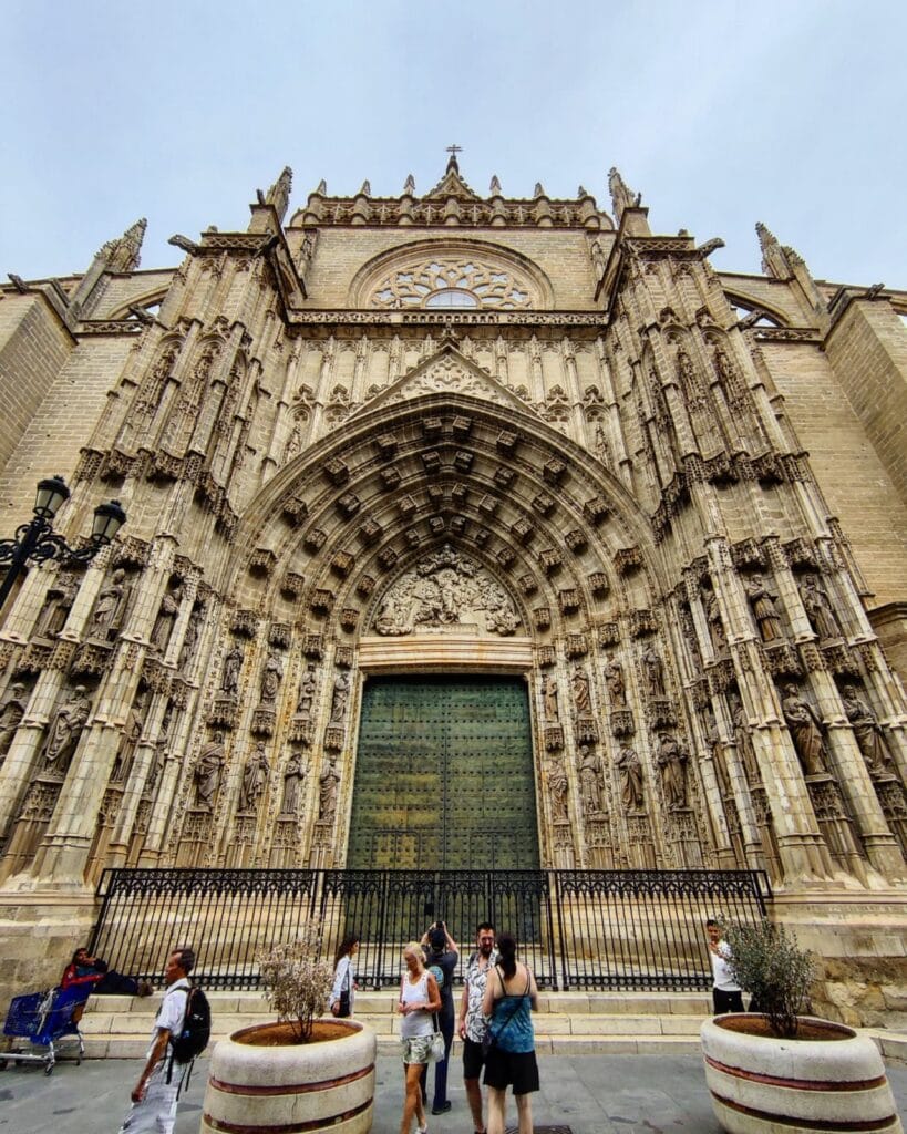 Gothic side portal of Seville Cathedral with carved stone sculptures