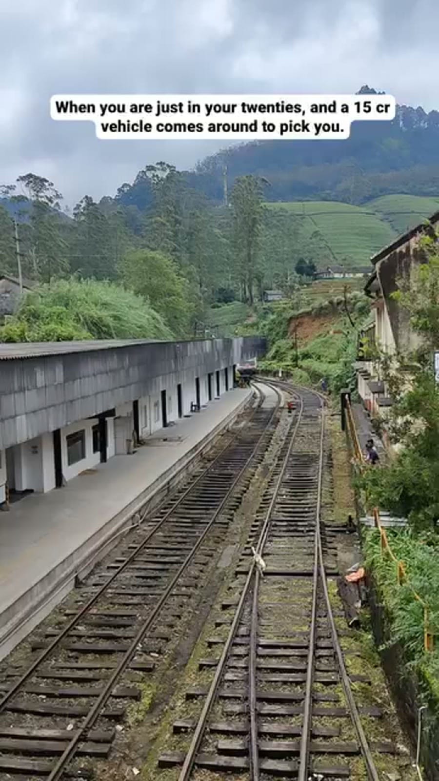 Blue hill-country train pulling in, story frame joking about a 15-crore vehicle coming to pick you up