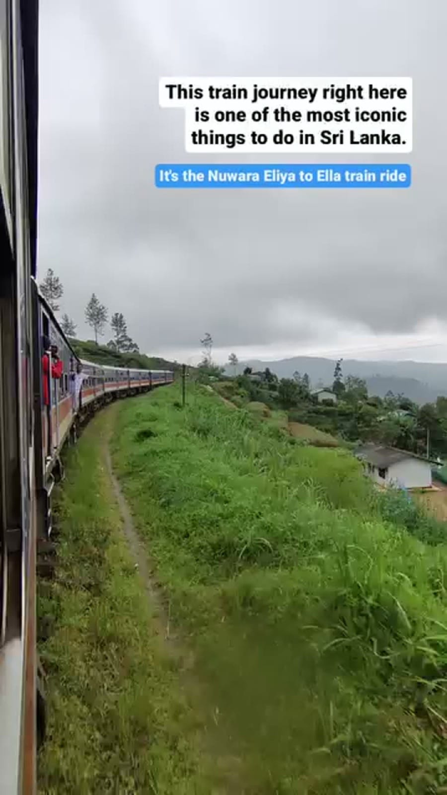 Passengers hanging out of the doors of the blue Nuwara Eliya to Ella train as it curves through green hills
