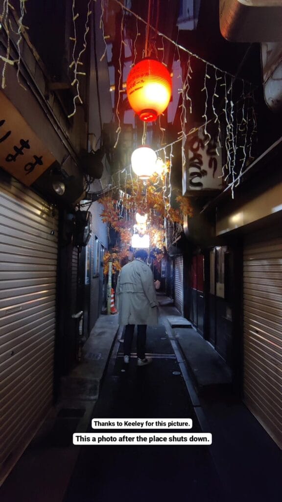 Alleyway in Golden Gai after hours with red lantern and decorative strings