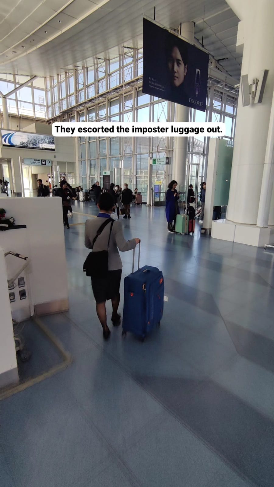 An ANA staff member wheeling the mistaken blue suitcase through Haneda Airport terminal