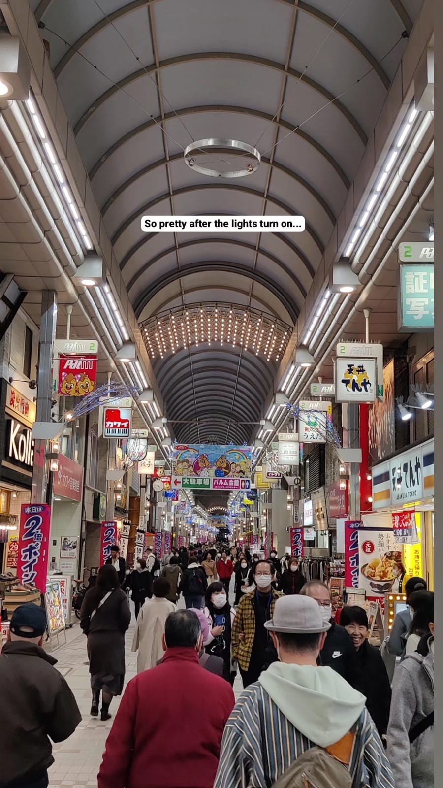 Musashi-Koyama Palm arcade lit up after dark with glowing shop signs and evening shoppers