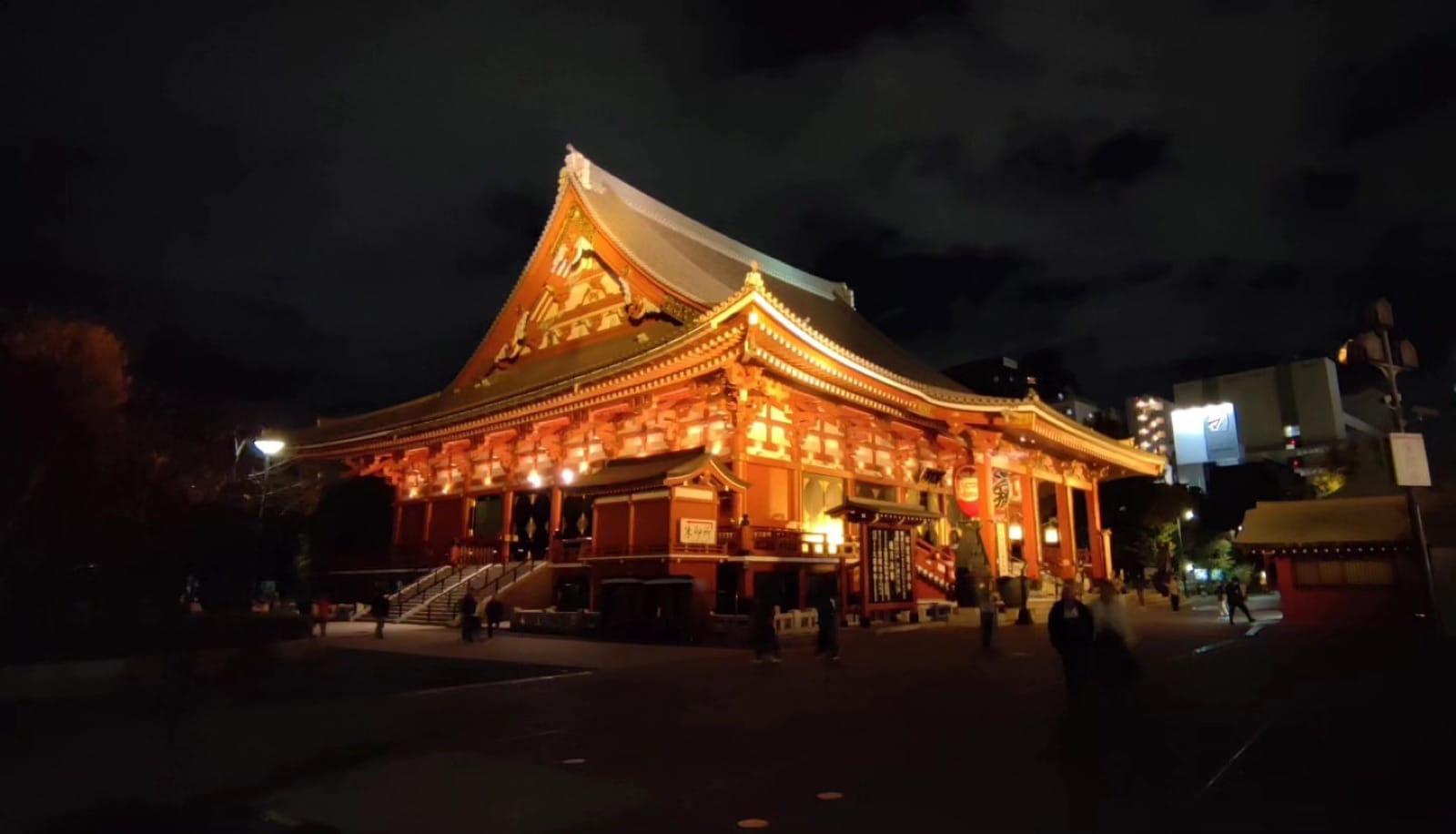 Senso-ji temple main hall glowing under floodlights at night in Asakusa, Tokyo