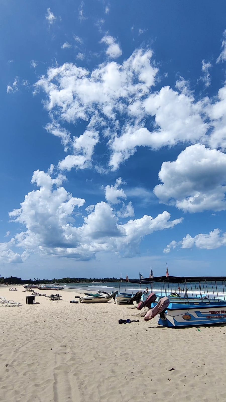 Towering clouds over Uppuveli beach and fishing boats in Trincomalee, Sri Lanka