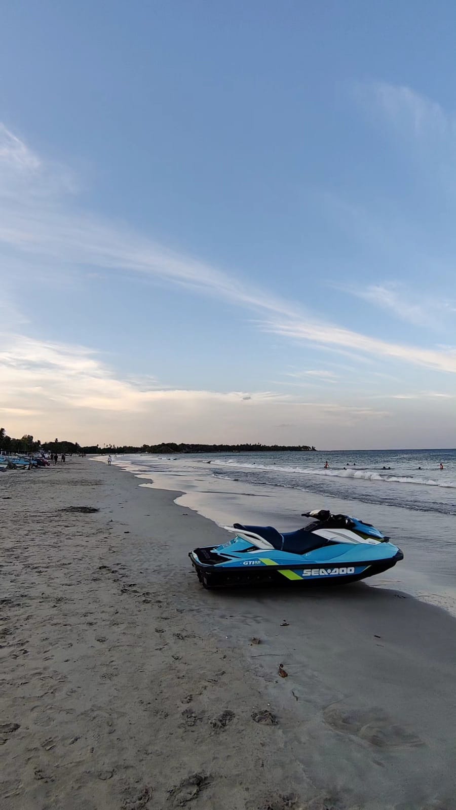 Golden hour light on the Uppuveli shoreline with a jet ski by the water in Trincomalee