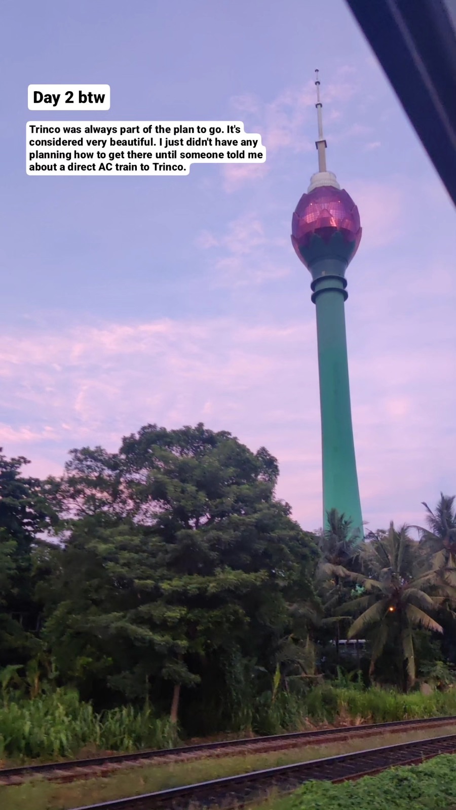 The Lotus Tower against a lavender dawn sky, seen from the train leaving Colombo