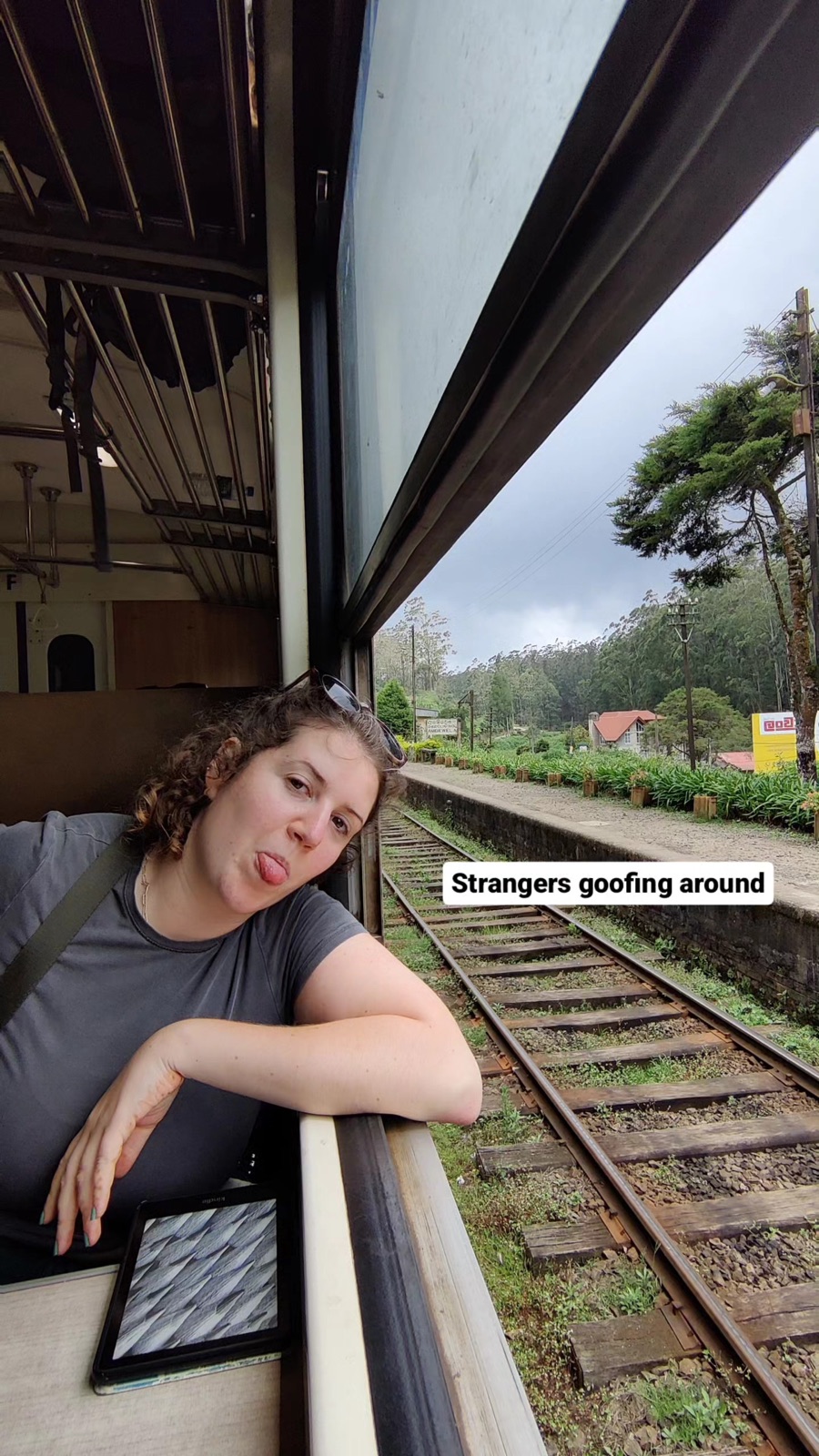 A fellow traveller pulling a face out of the train window, strangers goofing around